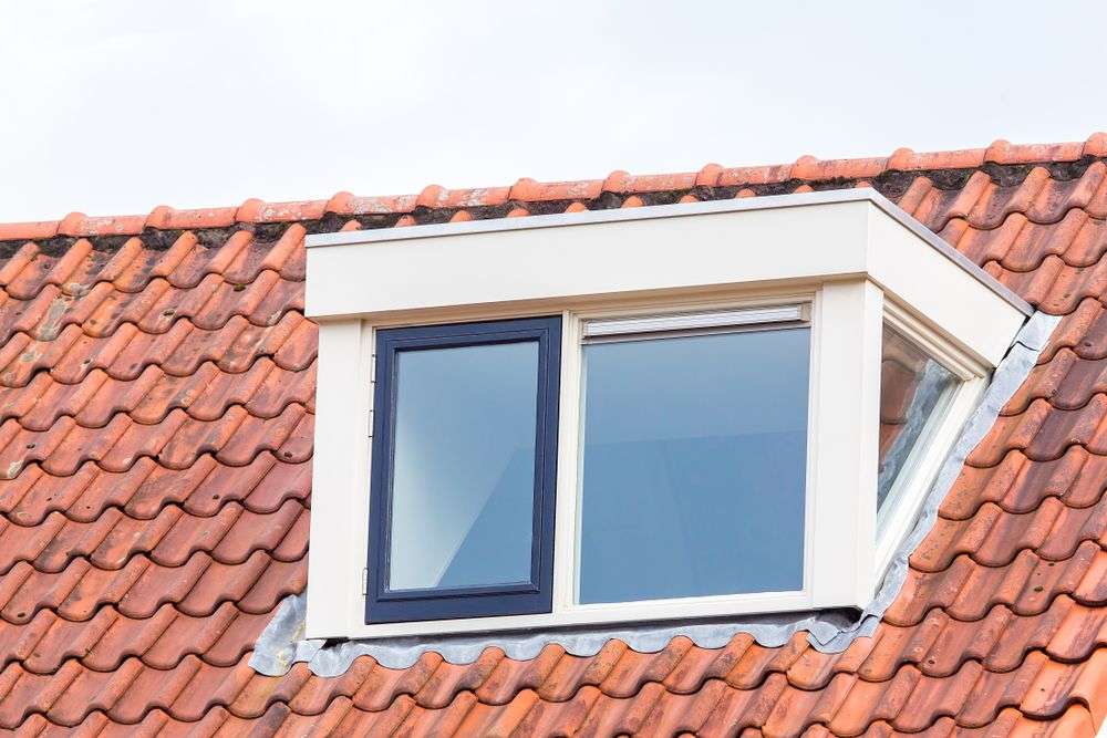 Verouderde loodslabben rondom een dakkapel